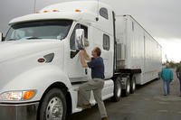 A trucker drives a white semi.