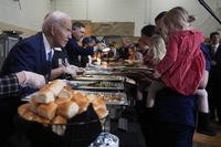 President Joe Biden serves food at a Friendsgiving event with service members and their families in the Staten Island borough of New York.