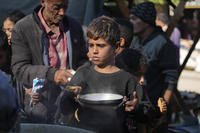 A Palestinian child queues for food in Deir al-Balah