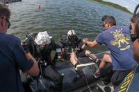 Navy divers assigned to Mobile Diving and Salvage Unit (MDSU) 2 are lowered into the water on Joint Expeditionary Base Little Creek during a Mk-16 underwater breathing apparatus training dive in Virginia Beach, Virginia.