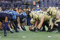 The Navy Midshipmen and the Army Black Knights line up for the snap at the line of scrimmage during the first quarter of an NCAA football game at Gillette Stadium