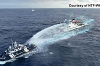 Chinese coast guard vessel, right, fires a powerful water cannon on a Philippine bureau of fisheries vessel