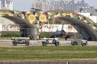 Taiwanese air ground troop vehicle moves past an airplane fort at an airbase in Hsinchu