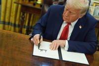 President Donald Trump signs an executive order in the Oval Office