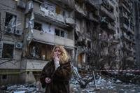 Natali Sevriukova reacts next to her house following a rocket attack on the city of Kyiv, Ukraine