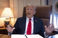 President Donald Trump speaks to reporters aboard Air Force One.