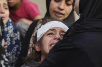 Yamama Jundia, grieves alongside others over the bodies of their relatives