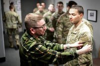 Civilian Airman Nicholas Holland, left, a photographer assigned to the 673d Air Base Wing Public Affairs, helps Army Private Juan Pacheco, a replacement in the 11th Airborne Division, adjust his uniform before having his official Individual Readiness Processing Program photograph taken at Joint Base Elmendorf-Richardson, Alaska, March 14, 2025. (Justin Connaher/U.S. Air Force)