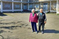 Mayka and Kao Xiong stand in front of General Vang Pao’s old house