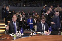 NATO Secretary General Mark Rutte, left, bangs a gavel