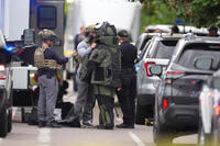 Law enforcement officials dress up in protective gear to investigate an attack on the Pearl Street Mall