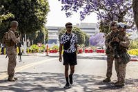 Marcos Leao, center, walks past a checkpoint manned by Marines.