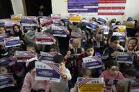 Afghan refugees hold placards during their meeting to discuss the situation after President Donald Trump paused the U.S. refugee programs