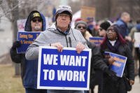 Protesters walk outside the John D. Dingell Veterans Affairs Medical Center