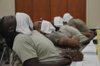 Soldiers assigned to the 3rd Infantry Division Sustainment Brigade use hot towels to warm their faces during a shaving clinic
