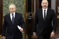 Russian President Vladimir Putin, left, and Azerbaijani President Ilham Aliyev enter a hall during a meeting at the Kremlin in Moscow, Russia
