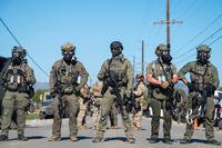 Federal immigration agents block the road during a raid in the agriculture area of Camarillo, Calif.