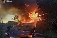 In this photo provided by the Ukrainian Emergency Service, firefighters put out the fire following a Russian attack in Kyiv region
