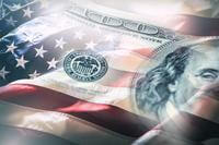 A US $100 bill and the US flag meld in a photo illustration.