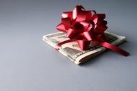 Folded cash topped by a red bow.