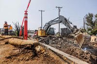 Contractors hired by the U.S. Army Corps of Engineers clean up a property damaged by wildfire in Pacific Palisades, California.