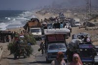 Displaced Palestinians fleeing northern Gaza carry their belongings
