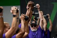 Veterans in matching PT uniforms lift kettlebells.
