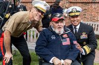 Two admirals pose with a veteran.