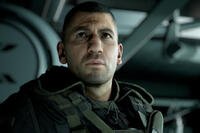 Close-up in-game render of a stern-faced soldier in tactical gear and dog tags inside an aircraft, portraying antagonist Cole D. Walker from Ghost Recon: Breakpoint.