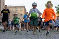 Kids run along a road in Italy.