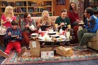 Scene from The Big Bang Theory: seven friends eat Chinese takeout around a coffee table.