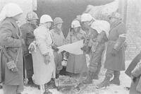 Black and white photo of WWII Army personnel standing up, looking at a map.
