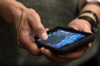 Hands hold a cell phone.