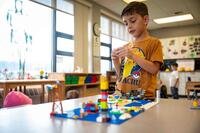 A child plays with blocks at a desk.