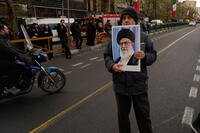 A man holds a poster of the Iranian Supreme Leader Ayatollah Ali Khamenei .