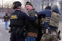 Law enforcement detain a man outside the Bishop Henry Whipple Federal Building during a protest on Saturday, Jan. 17, 2026, in Minneapolis. (AP Photo/Yuki Iwamura)