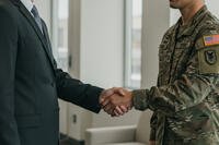 Veteran shakes hand with man in suit