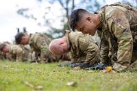 Ranger School candidates do pushups in the grass.