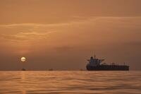 The sun rises behind tankers anchored in the Strait of Hormuz off the coast of Qeshm Island, Iran.