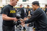 Soldier receives instruction in a dumbbell exercise.