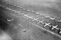 C-47 transport planes are loaded with men and equipment at an airfield in Holland.