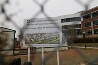 In this Thursday, April 2, 2015 file photo, and seen through the criss-cross pattern of a cyclone fence, the sign marking construction stands at the site of the Veterans Affairs hospital in Aurora, Colo.  (AP Photo/David Zalubowski, file)