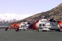 Two Coast Guard HH-60J helicopters and one HH-65A helicopter sit on the tarmac of Air Station Kodiak awaiting the next call for help. (U.S. Coast Guard photo by PAC Tod A. Lyons, USCG)