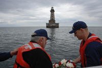 Former Coast Guard member Walter Scobie and Petty Officer 1st Class Christopher Connolly prepare to lay a wreath in Lake Superior near the Stannard Rock Lighthouse, June 17, 2015. (U.S. Coast Guard photo by Senior Chief Alan Haraf)