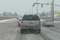 Cars driving on wet road at an intersection.