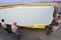Airmen of the 380th Air Expeditionary Logistics Readiness Squadron arrange a 200,000-gallon fuel bladder at an undisclosed location in Southwest Asia, April 4, 2013. (US Air Force photo/Christina Styer)