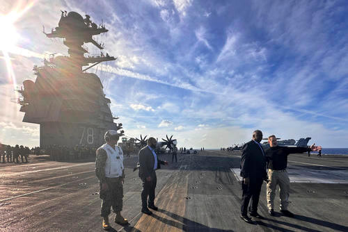Defense Secretary Lloyd Austin talks with the commanding officer of the USS Gerald R. Ford.