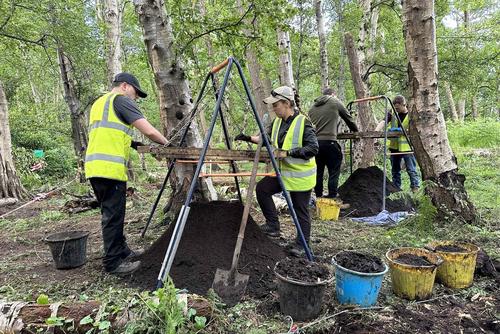 Active-duty US military personnel sieving woodland soil for human remains