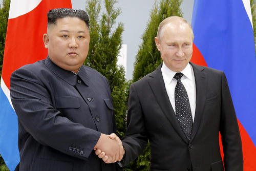 Russian President Vladimir Putin, right, and North Korea's leader Kim Jong Un shake hands
