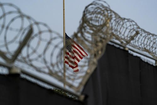 flag flies at half-staff as seen from Camp Justice in Guantanamo Bay Naval Base